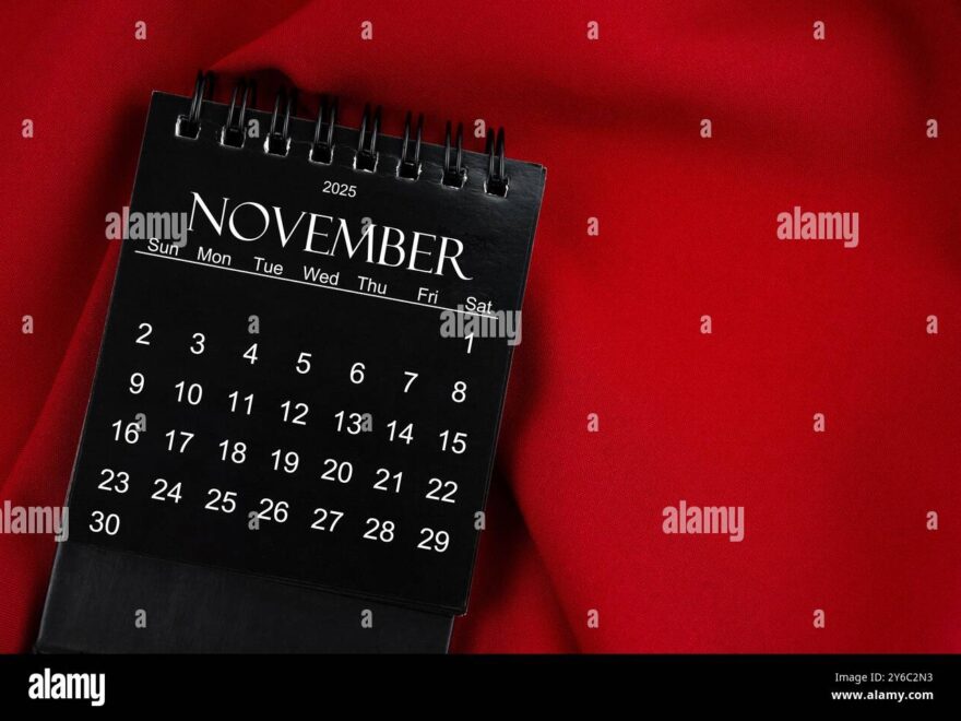 November 2025 Black Spiral Desktop Calendar On Red Textile Background Stock Photo Alamy