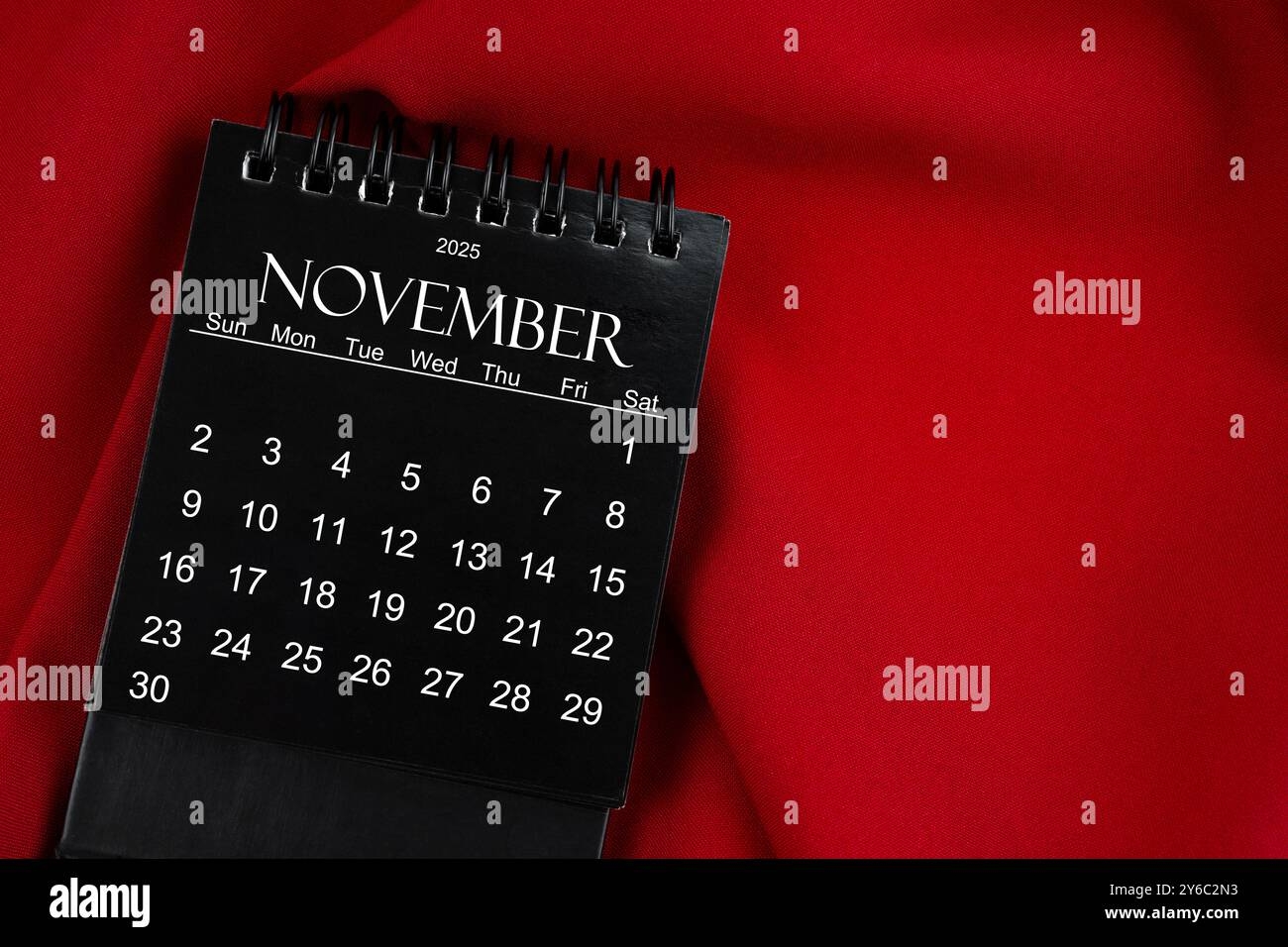 November 2025 Black Spiral Desktop Calendar On Red Textile Background Stock Photo Alamy